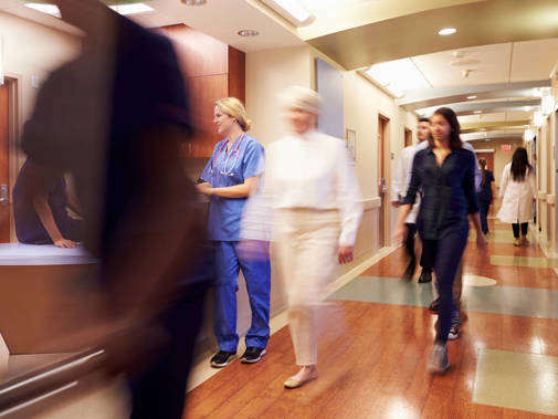 Busy hospital with blurred figures moving through a reception area