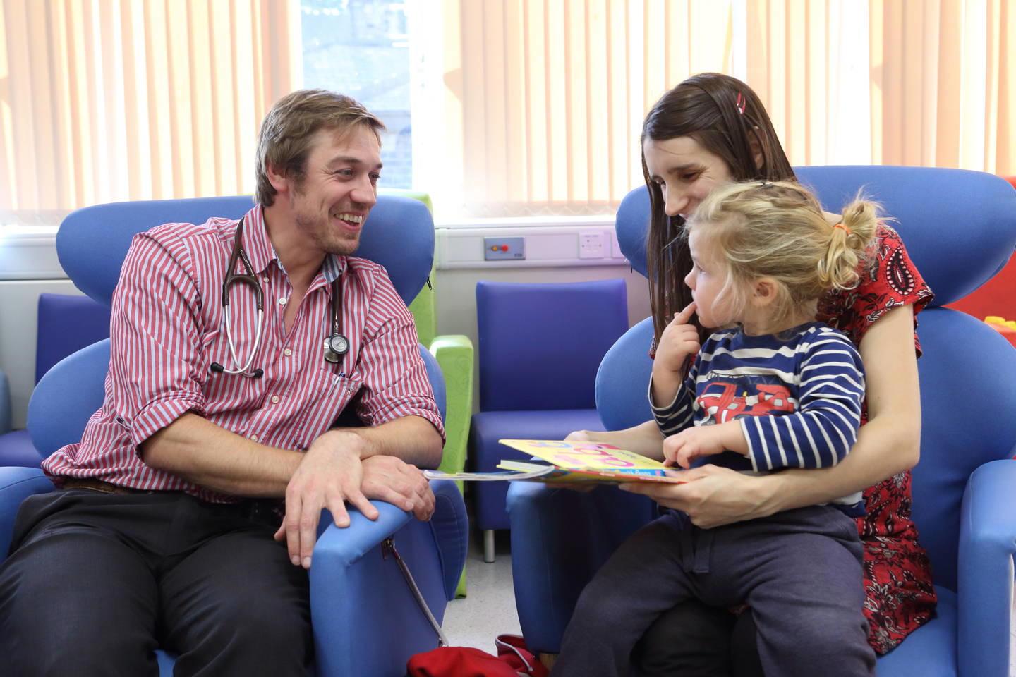 24470 male junior doctor talking to young patient and parent May 2017