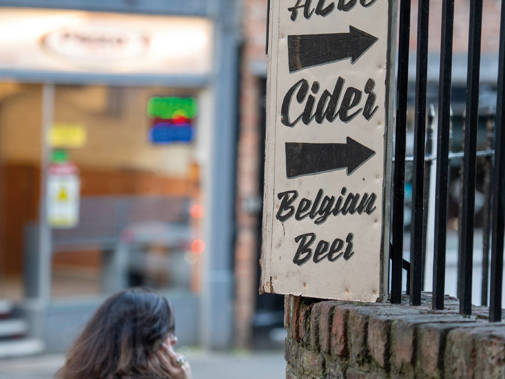 A hand-painted sign advertising cider, Belgian beer and ale on a street in York
