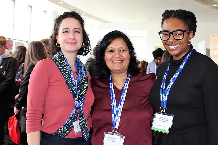 Three members of BMA staff at an event wearing lanyards and smiling to camera