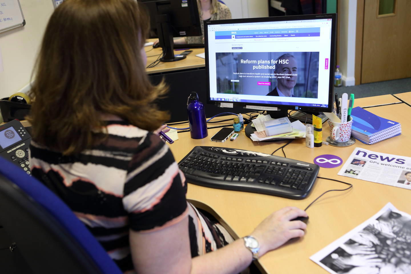 Back of a woman sat scrolling on her laptop which shows the BMA website