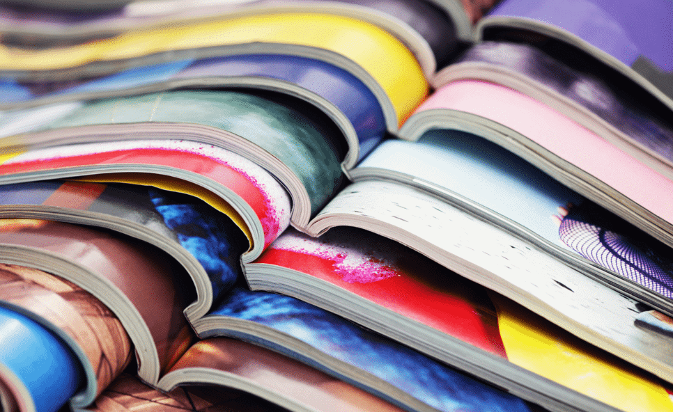 A detail of a stack of magazines staggered and lying open