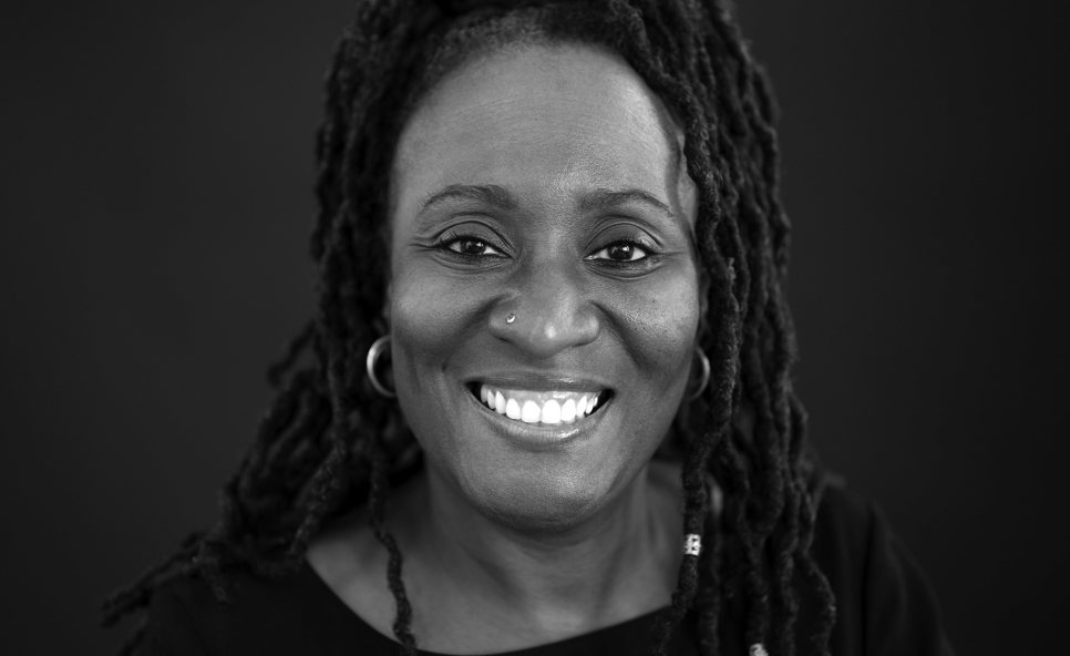 Black and white image of a woman smiling and looking straight at the camera