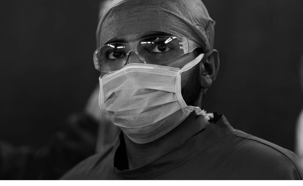 A black and white image of a doctor in scrubs and mask. A tagline on the image promotes 'BMA fairness for the frontline' campaign