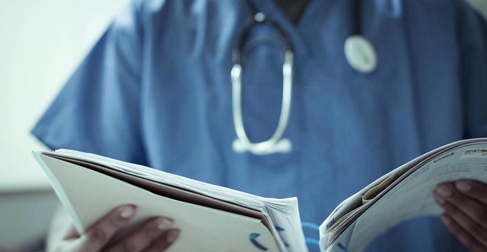 Doctor in scrubs reviewing patient file