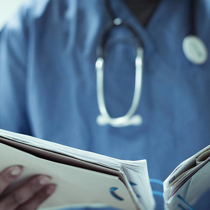 Doctor in scrubs reviewing patient file