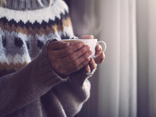 Detail Of Woman In Jumper Holding Mug To Warm Hands