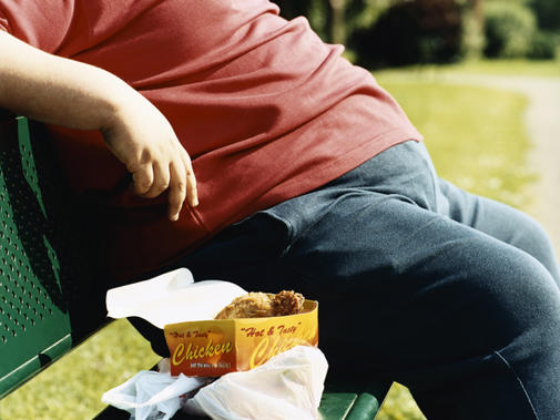 Obese Man On Park Bench Next To Fast Food Takeaway