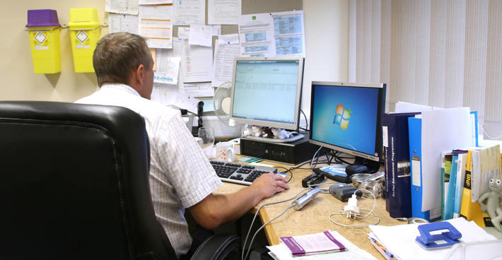 Male GP At Desk 